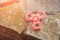 Popular Tri Fidget Hand Spinner spinning on stone background. Toned. Royalty Free Stock Photo