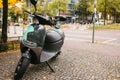 A popular vehicle in the city is called an electric scooter. In the background a street in Berlin. Royalty Free Stock Photo