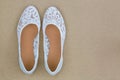 Popular white floral lace ballet flat slip on shoes on brown bac Royalty Free Stock Photo