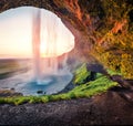 Populat tourist destination - Seljalandsfoss, where tourists can walk behind the falling waters. Perfect summer scene of Iceland,