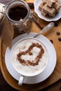 Porcelain cup of coffee with ice cream and cinnamon heart served  at black wooden table. life style concept. flat lay Royalty Free Stock Photo