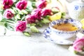 Porcelain cup of herbal green tea, lemon, mint and flowers on light grey background. Royalty Free Stock Photo