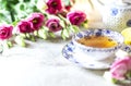 Porcelain cup of herbal green tea, lemon, mint and flowers on light grey background. Royalty Free Stock Photo