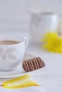 Porcelain cup of milk coffee and chocolate candy on a light background Royalty Free Stock Photo