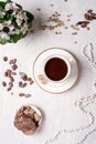 Porcelain cup of mocca coffee with natural chocolate, cocao beans, green coffe beans and neck beads around white provence