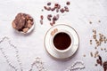 Porcelain cup of mocca coffee with natural chocolate, cocao beans, green coffe beans and neck beads around white provence