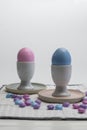 Porcelain Egg Cups with pink and blue Easter egg on a white napkin Royalty Free Stock Photo