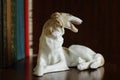 Porcelain figurine of a dog of breed Russian Greyhound on a bookshelf