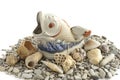 Porcelain fish and different shells on a white background. Royalty Free Stock Photo