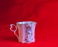 Porcelain pink cup of an unusual shape is made in the Czech Republic. A cup with a romantic pattern on a red background