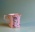 Porcelain pink cup of an unusual shape is made in the Czech Republic. A cup with a romantic pattern on a white background