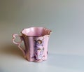 Porcelain pink cup of an unusual shape is made in the Czech Republic. A cup with a romantic pattern on a white background Royalty Free Stock Photo