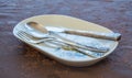 Porcelain plate with flower decorations, a silver knife, fork and a spoon on a decorated cover Royalty Free Stock Photo