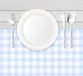 Porcelain plate and stainless cutlery on table with blue cloth Royalty Free Stock Photo