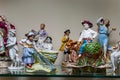 Assortment of rare porcelain figurines on glass shelf Royalty Free Stock Photo