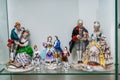 Assortment of rare porcelain figurines on glass shelf Royalty Free Stock Photo