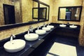 Row of wash basins with mirrors in a public toilet Royalty Free Stock Photo