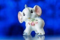 Porcelain statuette, porcelain statuette of the elephant on a blue background Royalty Free Stock Photo