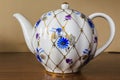 Porcelain sugar bowl, cup, milk, dish with golden pattern and blue flowers. Royalty Free Stock Photo