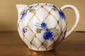 Porcelain sugar bowl, cup, milk, dish with golden pattern and blue flowers. Royalty Free Stock Photo