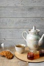 Porcelain tea kettle and teacup with green tea on a wooden background. Royalty Free Stock Photo