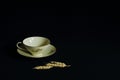 Exquisite tea cup on saucer made of thin porcelain with original floral ornament and ears of wheat on black background. Concept of Royalty Free Stock Photo