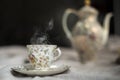 Porcelain tea pot and cup of hot tea on the table, antique traditional crockery set, high tea English afternoon tea Royalty Free Stock Photo