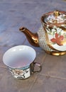 Porcelain teapot, teacup and saucer with floral rose ornament in classic style isolated over white