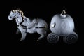 Porcelain toy carriage with horse. Ceramic`s pumpkin coach, black background, light painting photo in dark