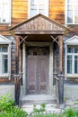 Porch of an abandoned two-story Moscow wooden house. Old wooden door with worn brown paint. Antique wooden house Royalty Free Stock Photo