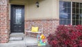 Porch with bench of a home with glass paned door and concrete and brick wall