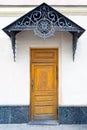 Porch with brown wooden door and forged decorative lattice on the pediment Royalty Free Stock Photo