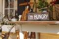 A porch decor consisting of an old wooden table with a rustic vintage kitchen scale, a straw basket,