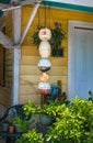 Porch And Entrance To Local Yellow Wooden Key West Home With Bouys And Plants Hanging By Door