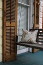 A porch swing and old wooden shutters