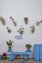 Porch of a house with a whitewashed wall with pots of colorful flowers and plants on the facade Royalty Free Stock Photo