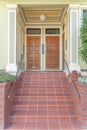 Porch with red tile doorsteps and three wooden front doors with transom windows at San Francisco, CA Royalty Free Stock Photo