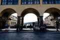 Porches on one side of the bridge over the river Arno, called `Ponte Vecchio` with people walking