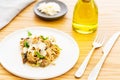 Porcini mushroom cream sauce linguini pasta with basil and parmesan. With cutlery, olive oil and parmesan on wood