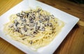 Mushroom and cream sauce spaghetti dish on wooden table