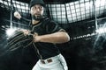 Porfessional baseball player with bat taking a swing on grand arena. Ballplayer on stadium in action. Royalty Free Stock Photo