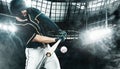 Porfessional baseball player with bat taking a swing on grand arena. Ballplayer on stadium in action. Royalty Free Stock Photo