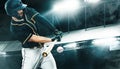 Porfessional baseball player with bat taking a swing on grand arena. Ballplayer on stadium in action. Royalty Free Stock Photo