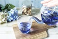 Poring bright blue butterfly pea flower herb tea to glass from a glass teapot Royalty Free Stock Photo