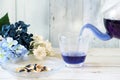 Poring bright blue butterfly pea flower herb tea to glass from a glass teapot Royalty Free Stock Photo