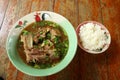 Pork backbone sour soup and rice on wood table.