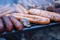 Pork and beef sausages cooking over the hot coals on a barbecue Royalty Free Stock Photo