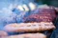 Pork and beef sausages cooking over the hot coals on a barbecue Royalty Free Stock Photo