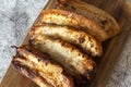 Pork belly pieces grilled cooked on a wooden chopping board.