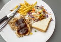 Pork black steak with french fried, salad, bread butter on a white round plate, top view image. Royalty Free Stock Photo